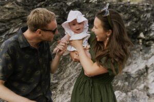 mum and dad holding up the baby